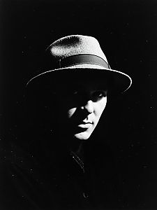 Dramatic Black and White Portrait of Man Wearing Fedora Hat with Cinematic Shadows