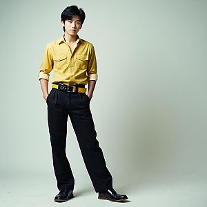 Confident Young Man in Yellow Shirt and Black Trousers