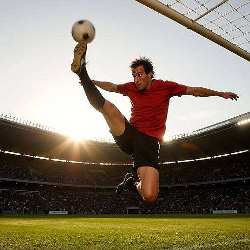 Male Soccer Player Executing High Kick Near Goal in Stadium