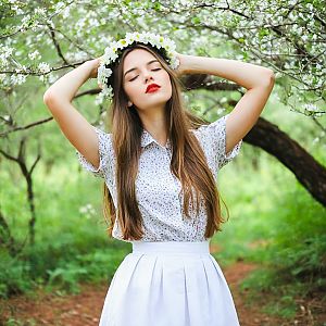 Young Woman in Floral Dress in Garden