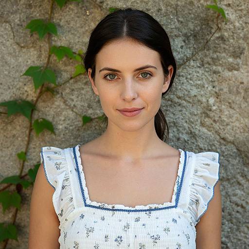 Woman in White Floral Dress Standing by Ivy-Covered Stone Wall