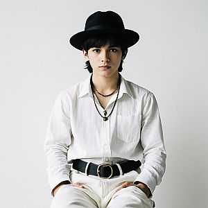 Young Man in Stylish White Outfit with Black Accessories