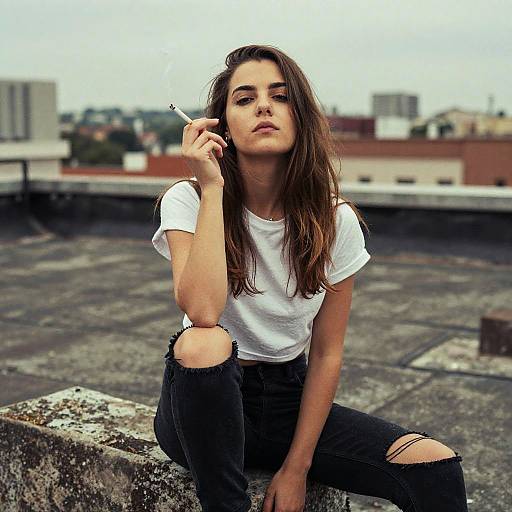 Young Woman Smoking on Urban Rooftop in Ripped Jeans