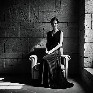 Elegant Woman in Black Dress on Armchair