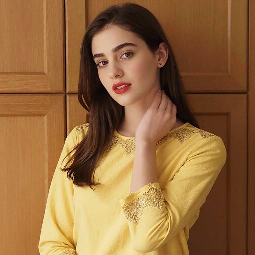 Young Woman in Yellow Embroidered Top Against Wooden Background