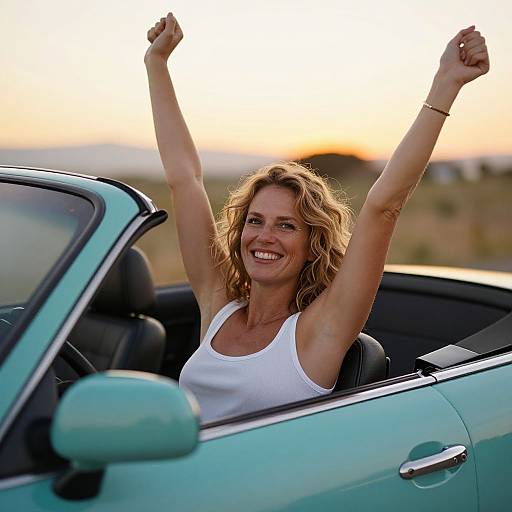 Happy Woman Enjoying Drive in Turquoise Convertible at Sunset