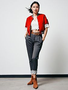 Fashionable Woman in Red Cropped Jacket and Gray Lace-Trimmed Trousers