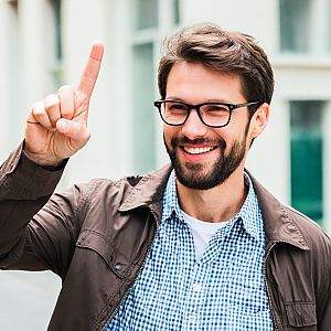 Cheerful man with glasses and beard in urban setting