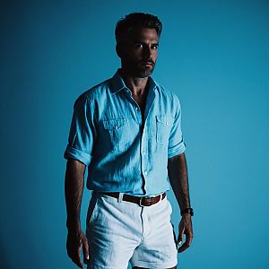 Confident Man in Casual Summer Outfit Against Blue Background