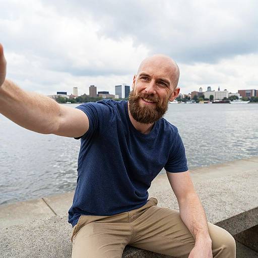 Man Taking Selfie by Waterfront with City Skyline Background