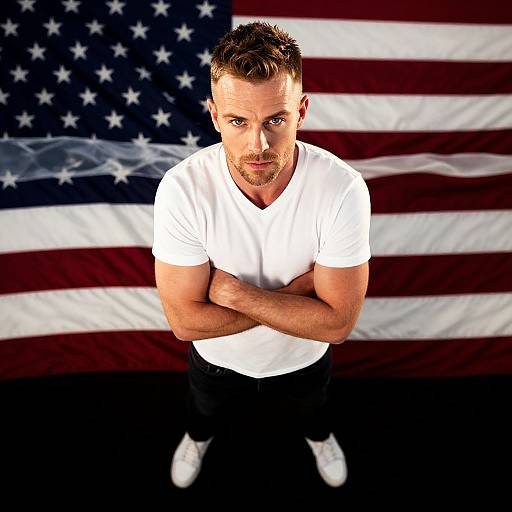 Confident Man Standing with American Flag Background in White T-Shirt
