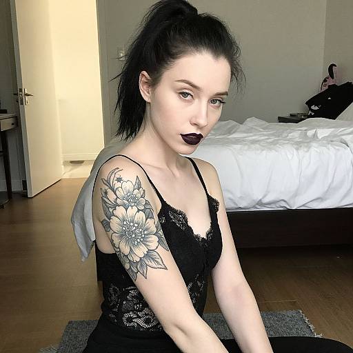 Young Woman with Floral Tattoo in Black Lace Top Indoors