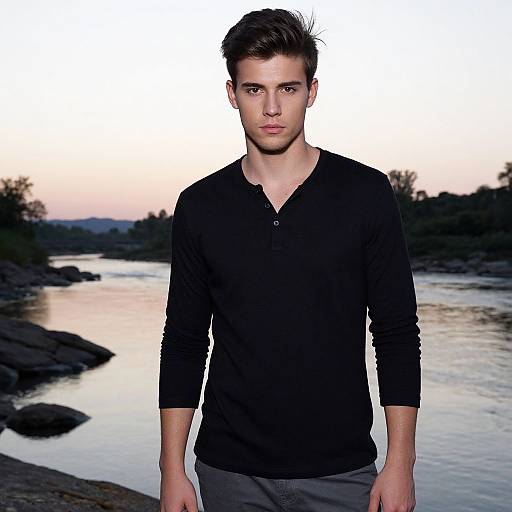 Young Man in Black Henley Shirt by River at Sunset