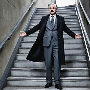 Confident man in grey suit on staircase