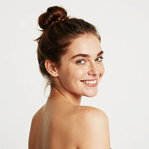 Smiling Young Woman with Natural Look and Top Bun Hairstyle