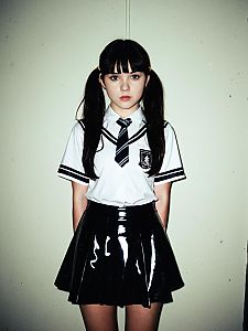 Young Woman in Latex Schoolgirl Uniform with Pigtails