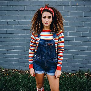 Young Woman Wearing Colorful Striped Shirt and Denim Overalls Outdoors