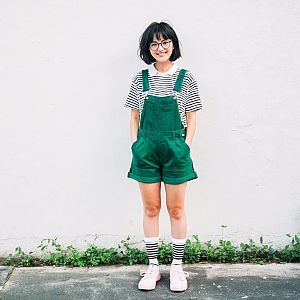 Young Woman in Green Overalls and Striped Shirt