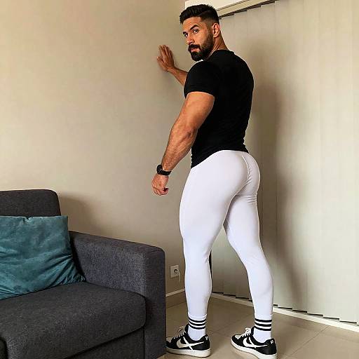 Muscular Man Wearing White Leggings and Black T-Shirt Posing Indoors