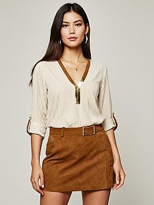Woman in Beige Striped Blouse with Gold V-Neck Detail and Brown Suede Skirt
