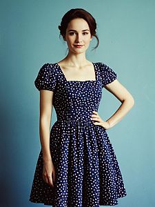 Young Woman in Vintage Navy Blue Polka Dot Dress Posing Confidently