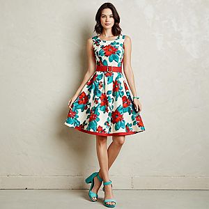 Woman in Ivory Knee-Length A-Line Dress with Bold Red Floral Print and Teal Accessories