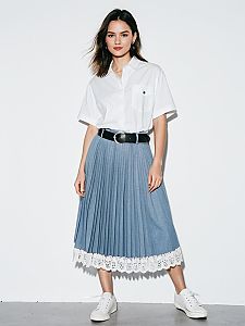 Young Woman in Casual White Shirt and Pleated Blue Skirt with Lace Trim