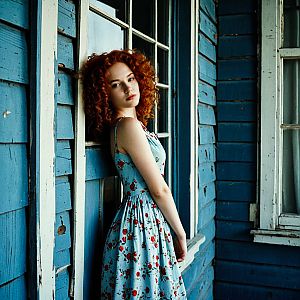 Thoughtful Young Woman with Red Hair in Floral Dress