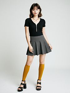 Woman Wearing Black Ribbed Short-Sleeve Top with Zipper and Gray Pleated Skirt