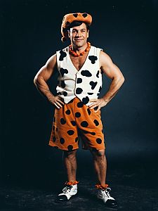 Man in Fred Flintstone Costume Cinematic Realism Playful Studio Portrait