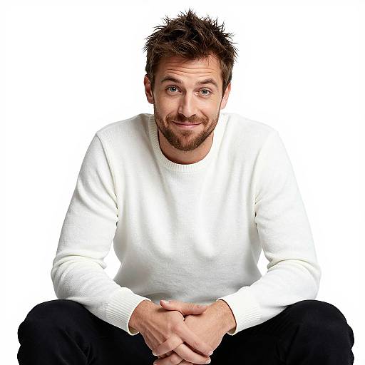 Confident Man in White Sweater Sitting with Warm Smile