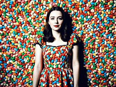 Woman in Colorful Jelly Bean Fancy Dress Standing Against Jelly Bean Background