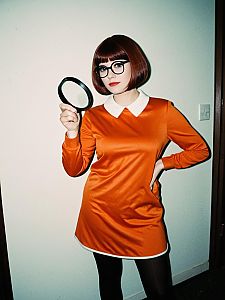 Woman in Velma Halloween Costume Holding Magnifying Glass Full Body Cosplay Photo