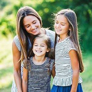 Joyful woman with two girls outdoors