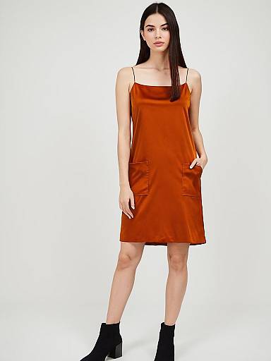 Woman in Minimalist Burnt Orange Spaghetti Strap Slip Dress with Pockets