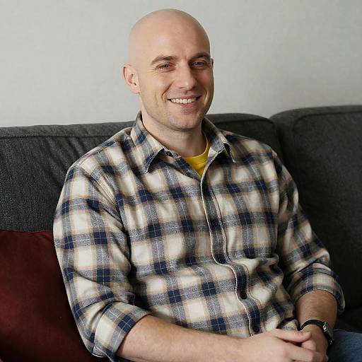 Smiling Bald Man on Couch with Pillow