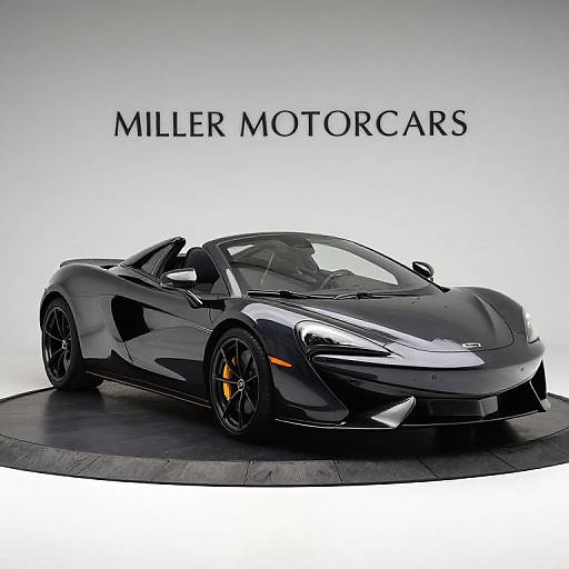 Photograph of a sleek, black McLaren sports car with yellow accents, displayed on a circular platform, against a white background with 