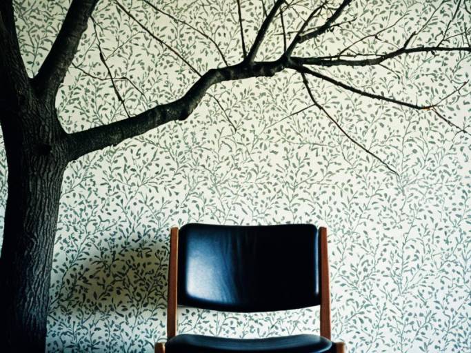 Chair in front of floral tree wallpaper