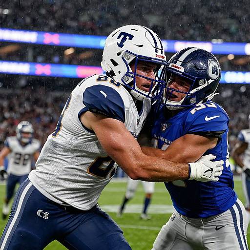 Photograph of intense football tackle: White-clad player with number 9, muscular build, collides with blue-clad player with number 2