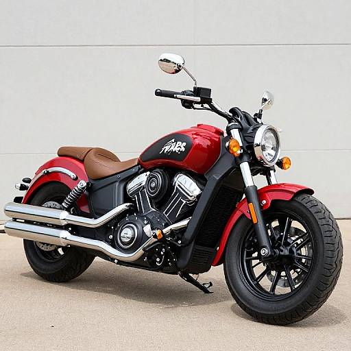 Photograph of a red Harley-Davidson cruiser motorcycle with black accents, chrome exhaust, brown leather seat, and black tires, parked on a concrete
