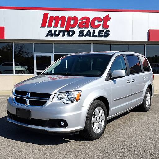 Photograph of a silver minivan in front of an 
