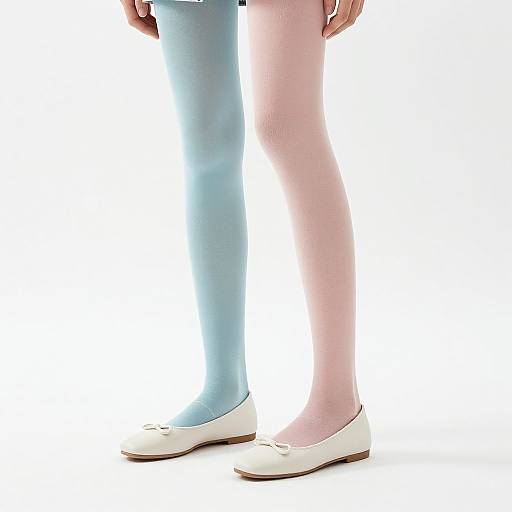 Photograph of a person's lower legs wearing pastel blue and pink tights, white ballet flats, against a white background.