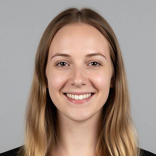 Photograph of a young Caucasian woman with light brown, shoulder-length hair, smiling, showing straight white teeth, light skin, and wearing a black top