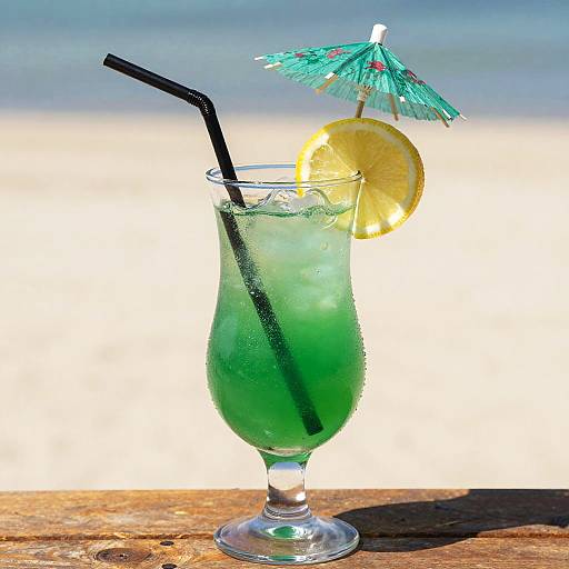 Green Cocktail with Lemon and Umbrella on Beach