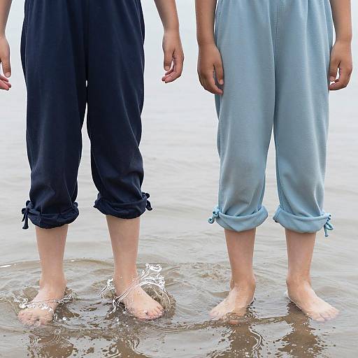 Children Standing Barefoot in Shallow Water