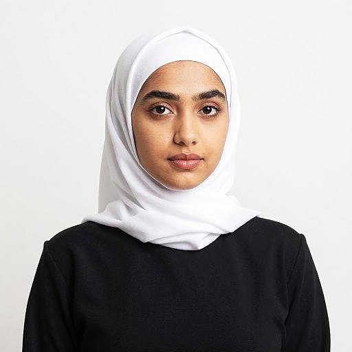 Photograph of a young woman with light brown skin, wearing a white hijab and black top, centered against a white background.