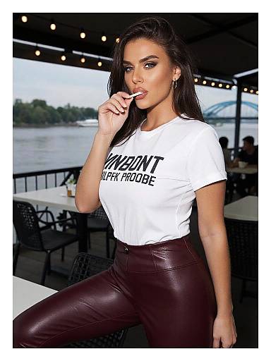 Photograph of a confident woman with long dark hair, white 