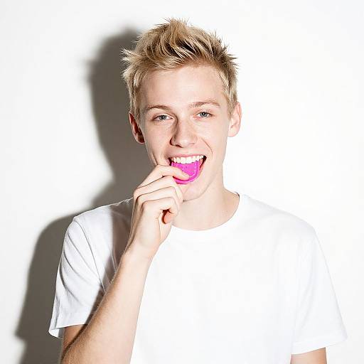 Playful Blonde Man Biting Pink Object