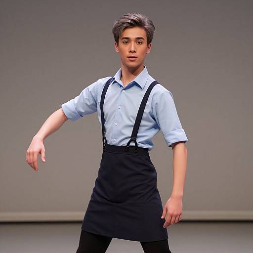  CGI image of a young man with light skin, short brown hair, wearing a light blue shirt, black suspenders, and black skirt, standing against