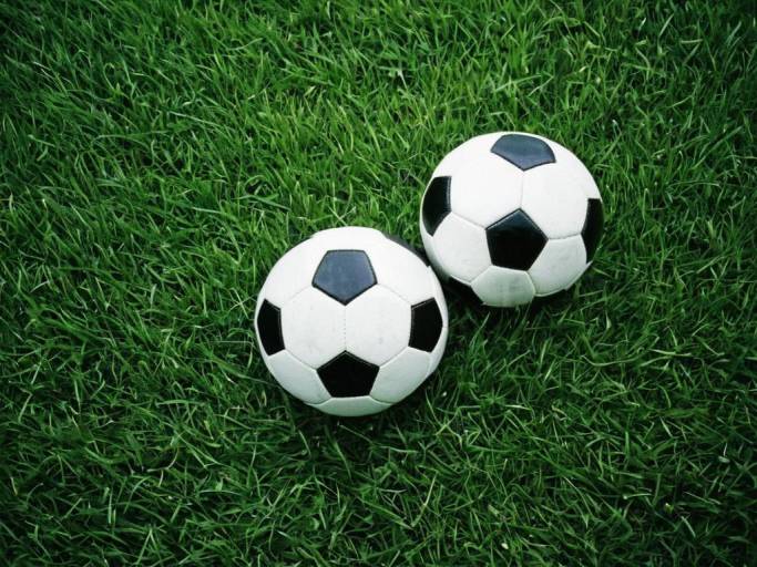Soccer Balls on Lush Grass Wallpaper